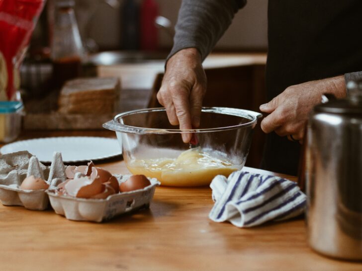 Man whisking scrambled eggs with soy sauce